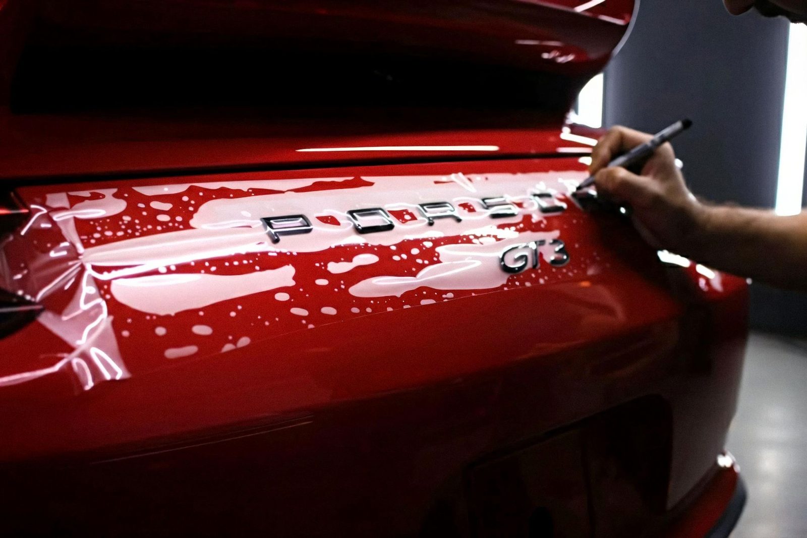 Aplicação de PPF na tampa traseira de um Porsche 911 GT3 vermelho